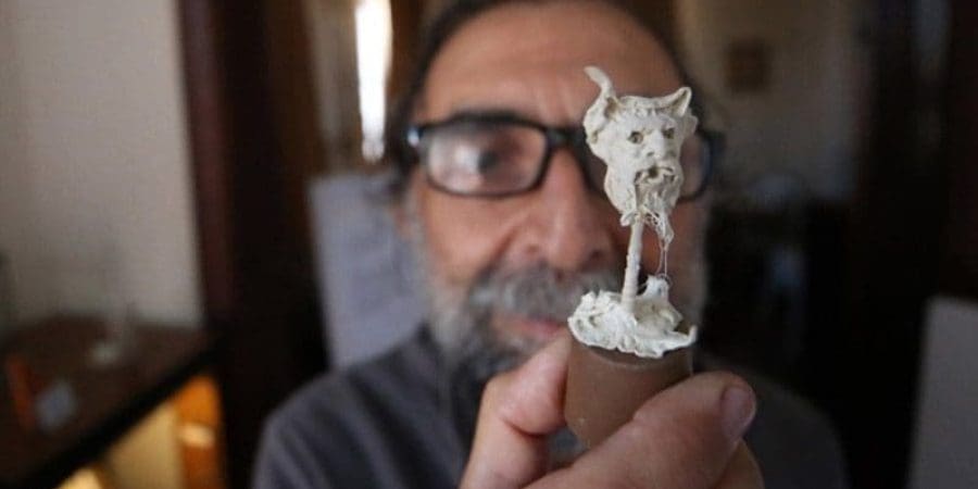 الفنان التركي نجاتي قورقماز يحمل تمثالًا صغيرًا صنعه باستخدام العلكة