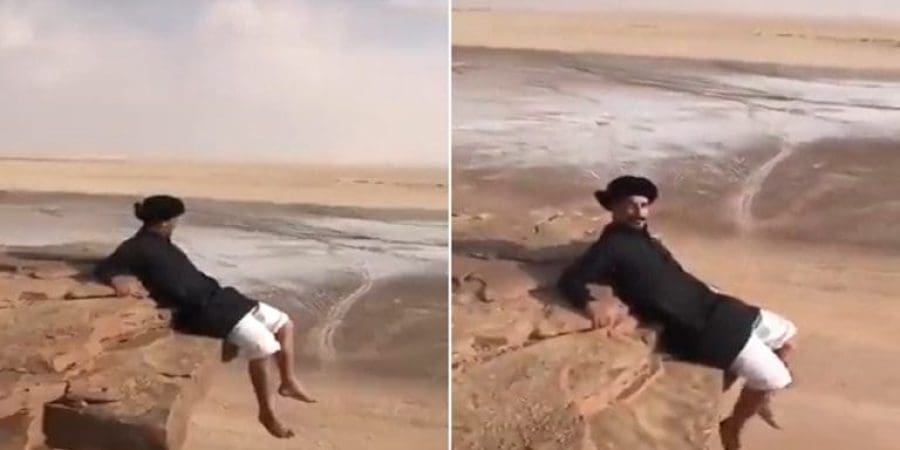 يظهر الفيديو الشاب وهو يجلس على حافة جبل على ارتفاع شاهق