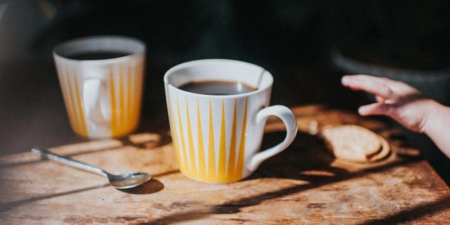 طفل يشرب كوبًا صغيرًا من الشاي