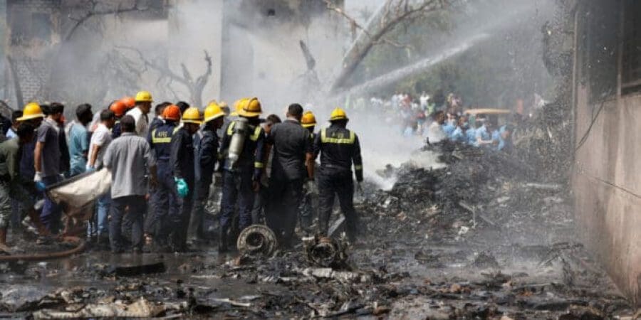 عمال إنقاذ يعملون فيما يتصاعد دخان من حطام طائرة من طراز بوينج 787-8 دريملاينر حيث تحطمت طائرة الخطوط الجوية الهندية في أحمد اباد بالهند يوم الخميس.